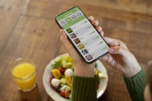 Mulher usando o celular e os aplicativos para calcular calorias